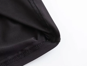 Detailed close-up of high-quality stitching and texture on black nylon maxi dress