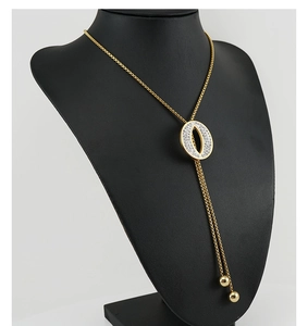 Detail of gold Y-shaped tassel necklace with crystal oval pendant on mannequin