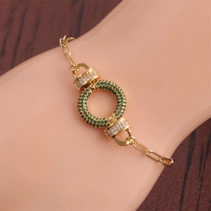 Close-up of hip hop gold bracelet with emerald and clear zircon round link charm