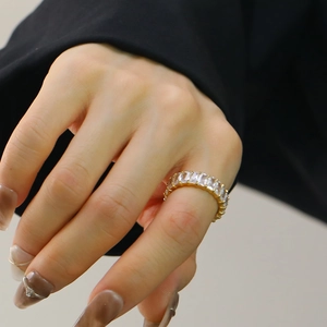 Close-up of gold titanium steel ring with baguette-cut white zircons worn on finger