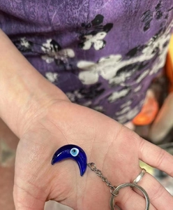 Detailed close-up of blue moon Evil Eye keychain with silver link chain and ring charm