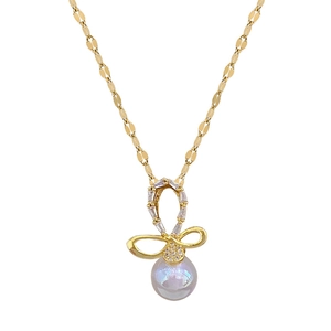 Elegant gold bow necklace with sparkling crystals and a dangling pearl on a steel chain