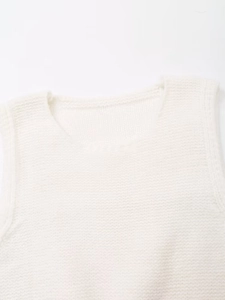 Detail view of white knitted vest showing round neck and high-quality shoulder stitching