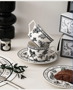 Detail of vintage ceramic coffee cup set with black and white botanical floral illustrations