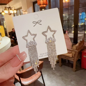 Close-up of sparkling star-shaped tassel earrings with 925 silver needles and crystals