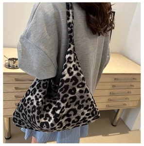 Detailed view of a trendy leopard print canvas tote bag carried by a model in a room