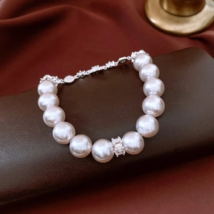 Detail of white pearl bracelet with diamond-set metal spacers and S925 silver tag