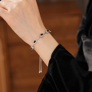 Detail eines verstellbaren Silberarmbands mit fünf ovalen schwarzen Steinen und Zirkonia