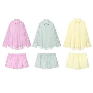 Flat lay of pink, green, and yellow striped shirt and shorts sets on white background