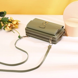 Detail of pea green crossbody bag with lychee texture and double zipper compartments