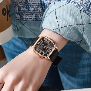 Gros plan sur la montre vintage carrée en or rose avec chiffres romains et bracelet cuir