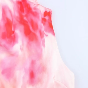 Primer plano detallado de la suave tela de satén de seda tie-dye en rojo, rosa y blanco