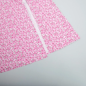 Close-up of pink floral print dress fabric with side slit seam and intricate petal patterns