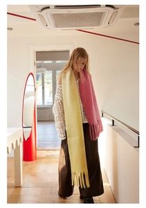 Detail view of pink and yellow wool blend gradient scarf with stylish fringe ends