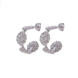 Detailed close-up of silver steel C-shaped earrings with connected sunflower motifs