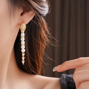 Close-up of long snake drop earrings with white pearls and sparkling marquise zircons