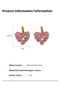 Détail macro de boucles d'oreilles cœur en zircon rose et cuivre plaqué or de 2,5 cm