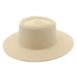 Detail of classic wide brim straw hat featuring flat top and fine woven texture