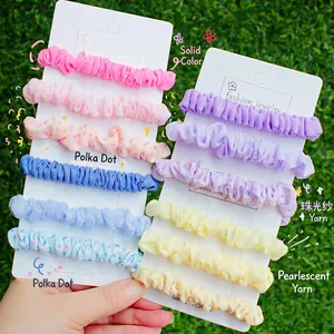 Set de chouchous en organza perlé aux couleurs pastel et pois sur fond de pelouse