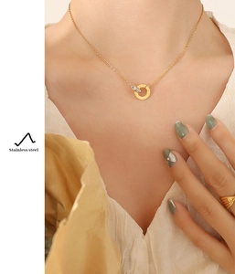 Detail of 18K gold-plated stainless steel Roman numeral necklace and crystal ring set