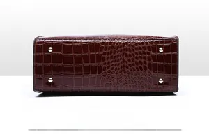 Detail view of burgundy faux crocodile leather bag base with four silver metal feet