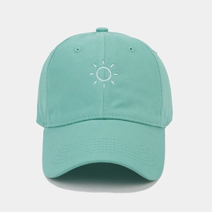 Detail of sun embroidery on a mint green soft-top baseball cap with premium stitching