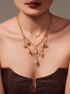 Close-up of gold layered necklace with zircon butterfly and sacred heart pendants
