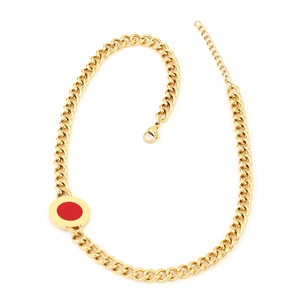 Detail of gold Cuban chain necklace featuring a red circular pendant and lobster clasp