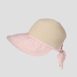Detail of pink bow and heart textured brim on a straw woven sun hat for women