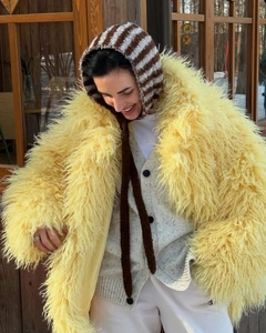 Close-up of vibrant yellow faux fur texture and oversized fluffy coat details