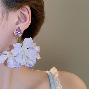 Close-up of purple fabric flower tassel earrings with water drop pendant on a model