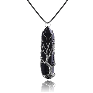 Macro shot of silver wire handmade tree of life wrapping on black stone pillar pendant