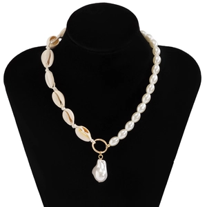 Close-up of Baroque pearl necklace with seashell beads on a black velvet display stand