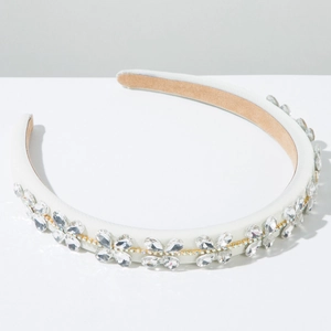 Close-up of baroque white headband with sparkling crystals and gold rhinestone chain