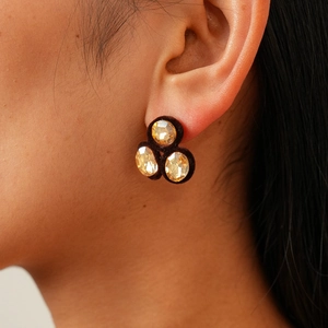 Macro detail of champagne crystal earrings with vintage brown flocked texture backing