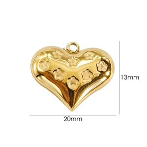 Detail of gold heart pendant with star relief measuring 20mm by 13mm on white background