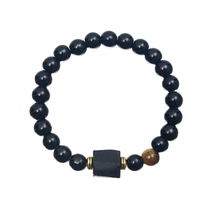 Macro detail of black beaded bracelet featuring tiger eye stones and a square textured bead