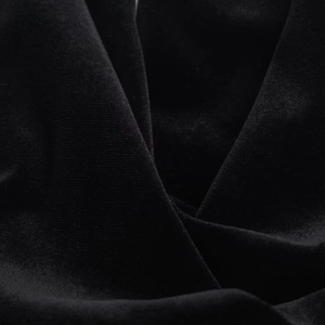 Vue détaillée en gros plan du tissu en velours noir avec plis élégants et texture douce