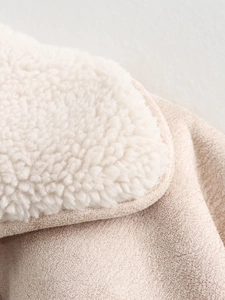 Close-up of soft white sherpa fleece lining and beige faux suede texture on jacket