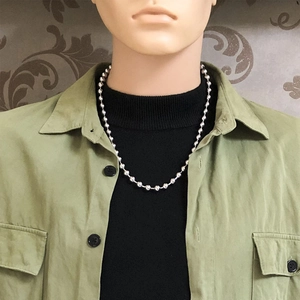 Men's titanium steel silver bead chain necklace worn by model against a textured wall