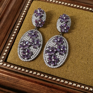 Macro detail of vintage floral oval earrings with purple stones and zircon inlay