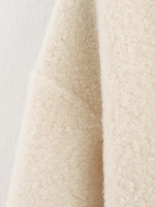 Primo piano della trama del tessuto in agnellino beige con dettagli delle fibre