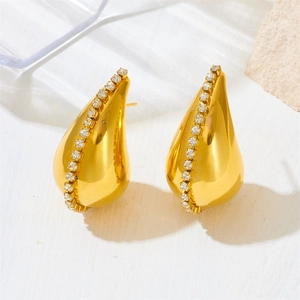Elegant gold teardrop earrings with cubic zirconia set on minimalist stone background