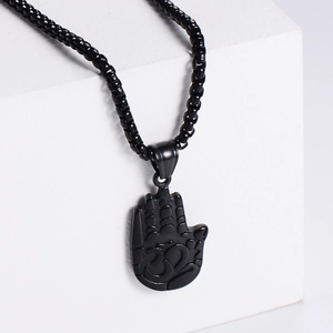 Vintage stainless steel necklace with a black palm pendant on a white display block