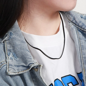Close-up of black sleek snake bone necklace worn by a model over a blue denim jacket