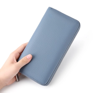 Detail of blue pebbled leather long wallet with silver metallic zipper and smooth texture