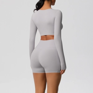 Achteraanzicht van tweedelige yogaset met crop top met lange mouwen en korte broek