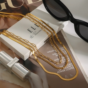 Close-up of golden multi-layer stackable necklace set with snake and paperclip chains