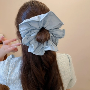 Vue détaillée arrière d'un chouchou bleu clair à volants sur une coiffure