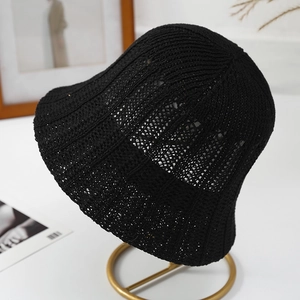 Elegant black crochet hollow-out bucket hat displayed on a golden metal stand